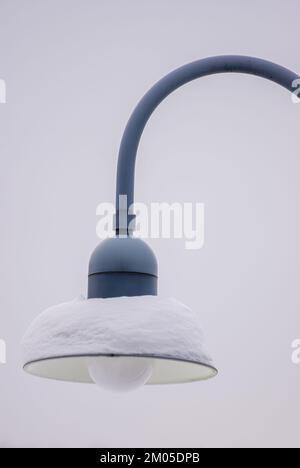 Snow-covered lamp of a public streetlight. Stock Photo