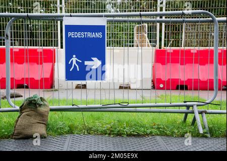 Pedestrian walkway sign at construction building site fence Stock Photo