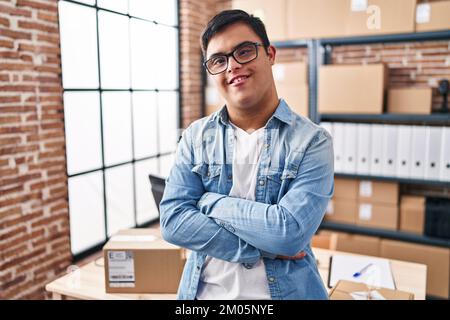 Down syndrome man ecommerce business worker standing with arms crossed gesture at office Stock Photo