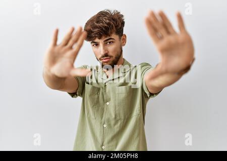 Young arab doctor man standing over isolated background doing frame using hands palms and fingers, camera perspective Stock Photo