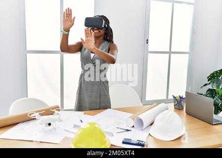 Young african american woman architect using virtual reality glasses at architecture studio Stock Photo