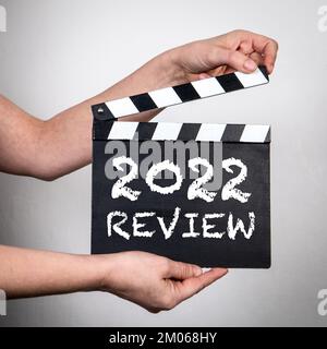 2022 Review. Female hands holding movie clapper. Business concept. Stock Photo