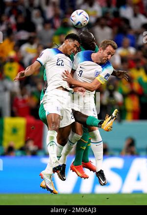Senegal's Kalidou Koulibaly battles for possession of the ball in the air with England's Jude Bellingham, (left) and Harry Kane (right) during the FIFA World Cup Round of Sixteen match at the Al-Bayt Stadium in Al Khor, Qatar. Picture date: Sunday December 4, 2022. Stock Photo