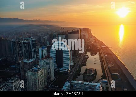 Aerial view of Batumi, Adjara, Georgia. Modern skyscrapers and hotels on coastline at sunset over Black Sea.