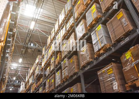 Retail warehouse full of shelves with goods in wooden crates, boxes and packages. Logistics, sorting and distribution for product delivery. Look up, l Stock Photo