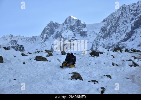 Indian tourists enjoy a sledge ride on a snow covered slope at Thajwas hill station, in Sonamarg, about 100kms northeast of Srinagar, the summer capital of Jammu and Kashmir. Stock Photo