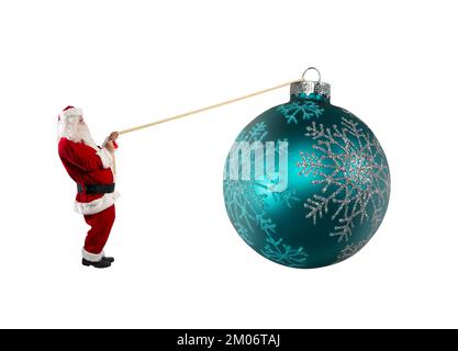 Santa claus pulls a rope to move a big christmas ball Stock Photo