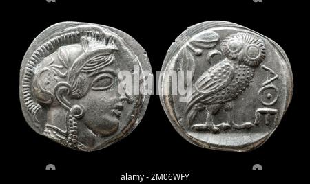 Ancient Greek coin showing goddess Athena and owl. Old rare money of Athens, silver tetradrachm isolated on black background, macro. Theme of Greece, Stock Photo