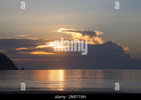 Sunset over the ocean between the clouds Stock Photo