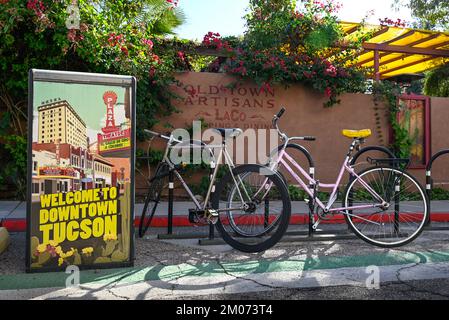 Entrance to the historic Old Town Artisans Block, located at the site of El Presidio San Augustin del Tucson, with signage and bicycles Stock Photo