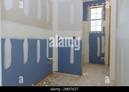 A newly constructed house in the process of being plastered drywall is ready for painting Stock Photo