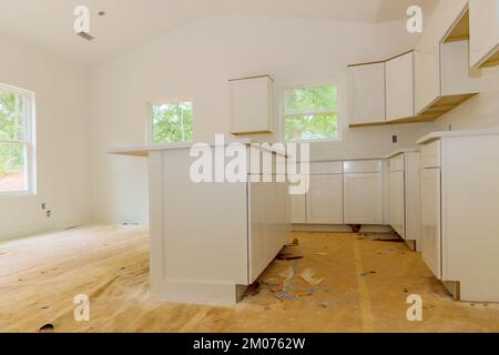 Installation of white kitchen cabinets in a newly constructed house Stock Photo