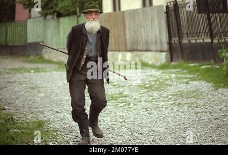 Prahova County, Romania, approx. 2000. Elderly man walking on the village lane. Stock Photo