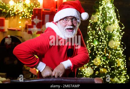 Santa Claus with vintage leather suitcase going on trip. New Year's travel. Concept of vacation. Stock Photo