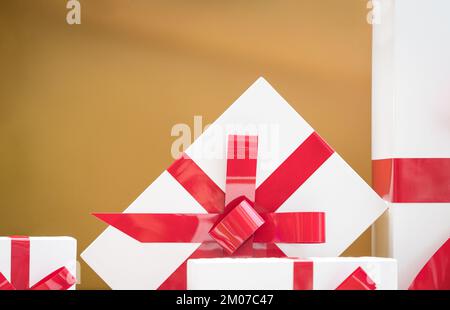 Gift boxes with red ribbons on gold background. For christmas and holiday concept. Copy space. Stock Photo