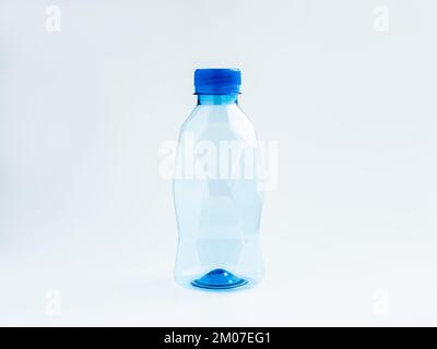 An empty geometry plastic water bottle with polygon shape, small size with blue cap cover and no label isolated on white background. Stock Photo