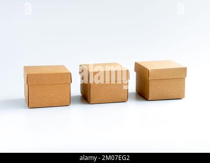 Three cardboard boxes isolated on white background. Carton gift box, presents. Square kraft paper box with lid on top. Delivery, parcel, packaging wit Stock Photo