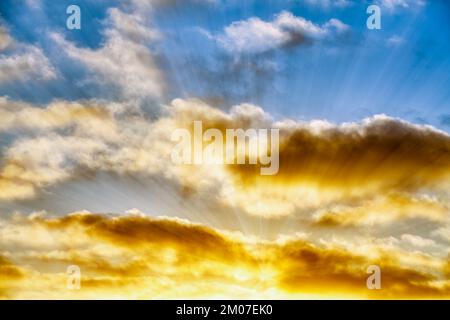 Sun Rays Are bursting Through The Golden Colored Clods Stock Photo