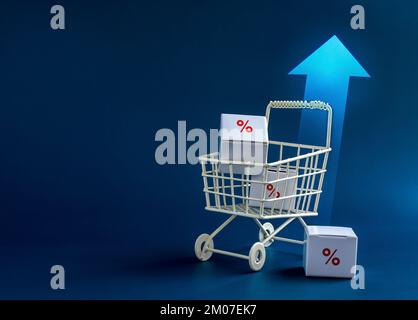 Inflation, increase sales, rising up price, business marketing concepts.  Red percentage icon on parcel boxes in white shopping cart trolley with risi Stock Photo