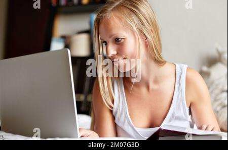 Breezing through her assignment. Young college student working on an assignment at home. Stock Photo