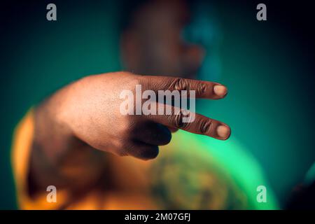Man Put up piece sign side ways dueces Stock Photo