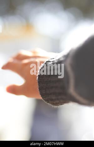 Reach for the sun. A closeup shot of a hand reaching out into the sunshine. Stock Photo