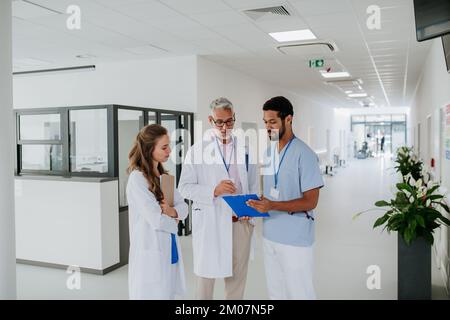 Doctors discussing something at hospital corridor. Stock Photo