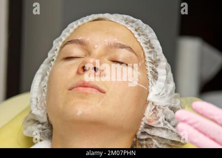 Attractive girl patient with instructions on her face for plastic surgery operation. Surgeon touching a person's face. The concept of aesthetic cosmet Stock Photo