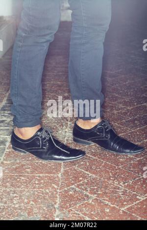 GIVE YOUR FEET SOME ACTION. a stylishly dressed mans feet on the sidewalk. Stock Photo