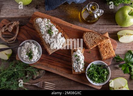 Roasted rye bread with cottage cheese salad on wooden table. Flat lay Stock Photo