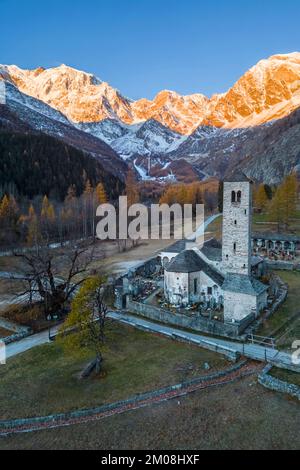 Sunrise in front of Monte Rosa from the old church of Macugnaga. Valle Anzasca, Ossola, province of Verbania, Piedmont, italian alps, Italy. Stock Photo