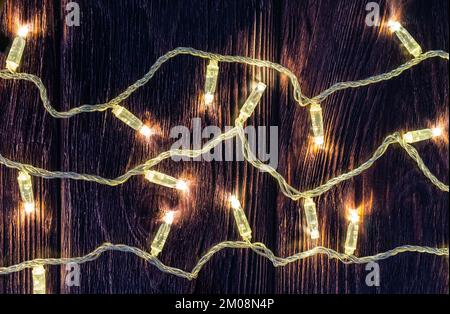 Christmas garland with warm white led and transparent wire on dark wood board Stock Photo