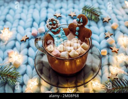 Concept of couples spa Christmas holiday. Couple woman and a man made out of an gingerbread that soak in cup of hot chocolate with marshmallows, cozy.