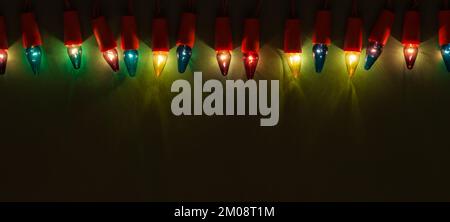 Christmas Lights of Different Colors on Dark Green Background. Retro Multicolored Light Bulbs Stock Photo