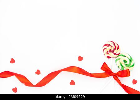 Two beautiful lollipops tied with a red ribbon in a bow on a white isolated. Stock Photo