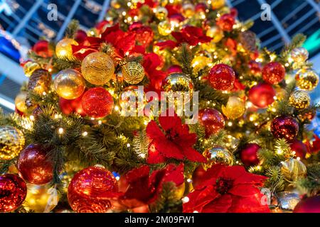Christmas tree full of lights, garlands, colorful balls and decorations. Abstract christmas background. Bottom-up view of christmas tree. Stock Photo