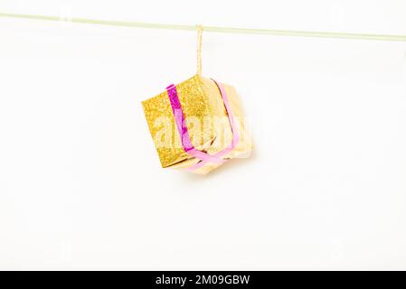 Christmas gift is hanging on isolated white background Stock Photo