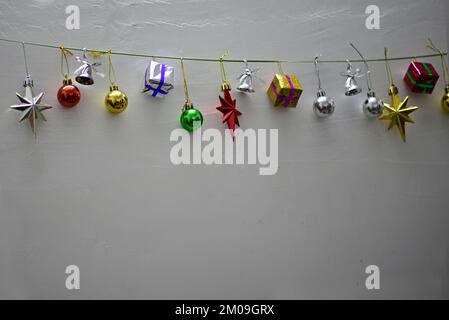 Christmas gifts are hanging on isolated grey background Stock Photo