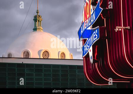 The white dome of Spanish City in Whitley Bay at sunset, with the neon sign of the TJ Leisure Amusements in the foreground, North Tyneside Stock Photo