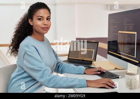 Portrait of female programmer working on computer in modern office of IT company Stock Photo