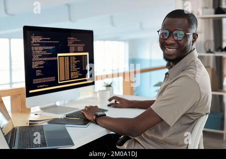 Portrait of smiling software engineer working on computer in office of IT company Stock Photo