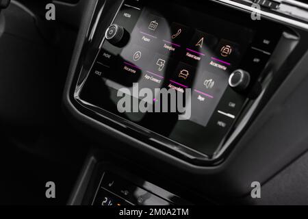 Modern car media display in the interior of the car. Touchscreen monitor on the dashboard of the modern car. Translation: 'Phone. Navigation. Radio. D Stock Photo