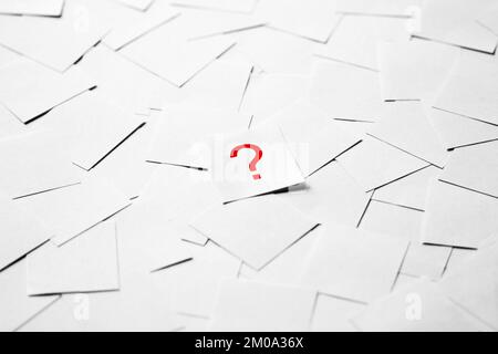 Pile of blank pieces of paper with red question mark in the middle Stock Photo