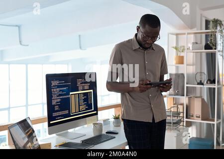 Serious software developer testing new application on digital tablet Stock Photo