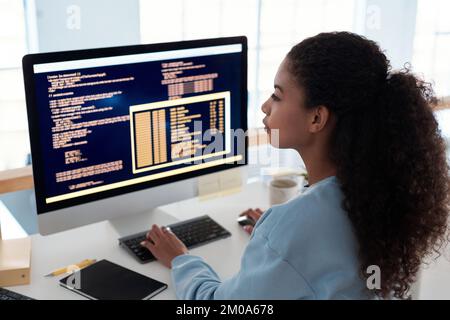 Serious female programmer writing code for testing computer software Stock Photo
