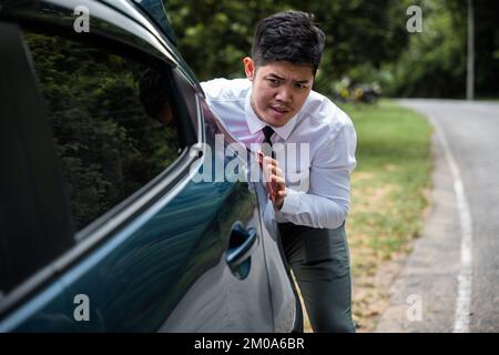 Asian businessman car broken has problems with car down during go to work in morning he pushing out of gas Stock Photo