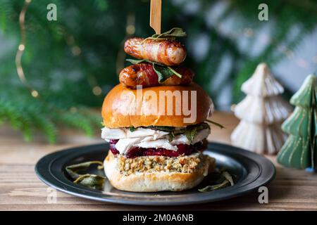 Christmas brioche bun with turkey, stuffing, cranberry sauce and pigs in blankets Stock Photo