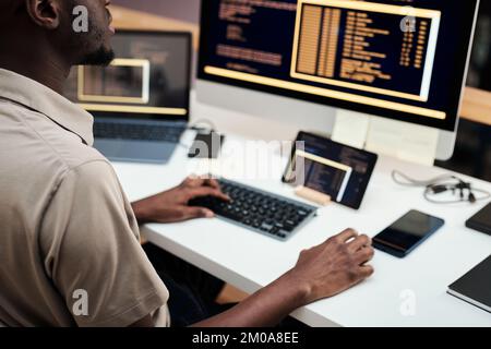 Software engineer deploying software on computer and various gadgets Stock Photo