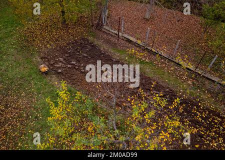 Aerial view of a ploughed vegetable garden field. Home garden prepared for winter. End of growing season. Stock Photo