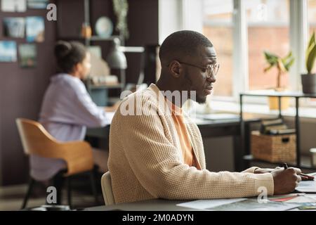 Side view of pensive graphic designer working on illustrations for new projects Stock Photo